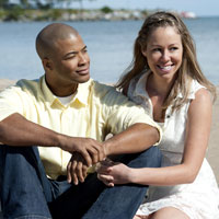 Guy holds flower with woman.